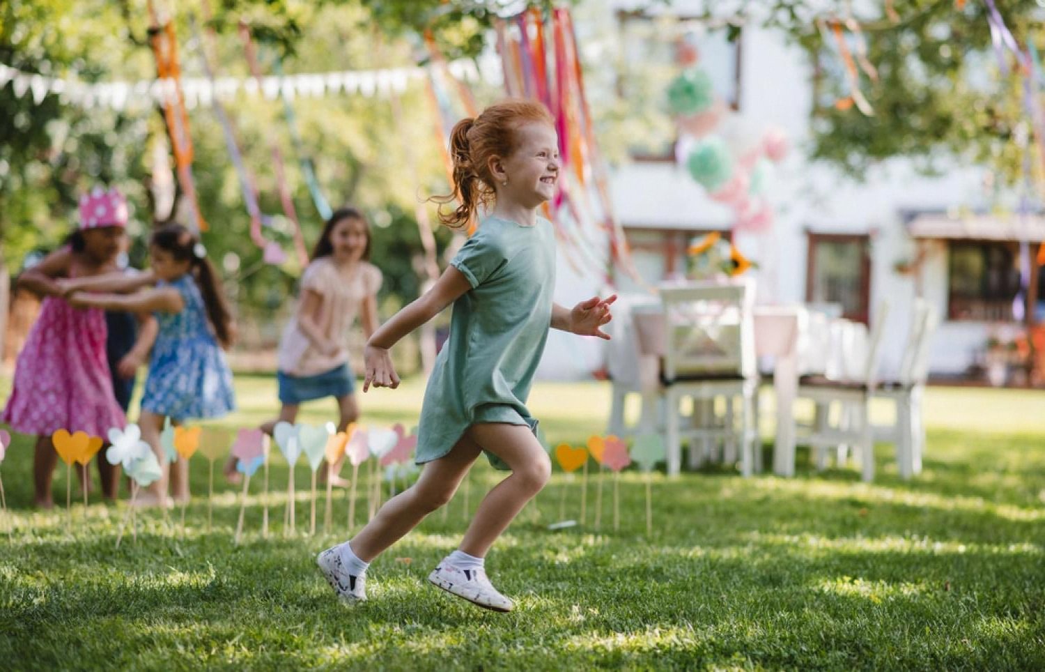 Children running at a Dubai garden party where mist fans and air coolers keep guests comfortable